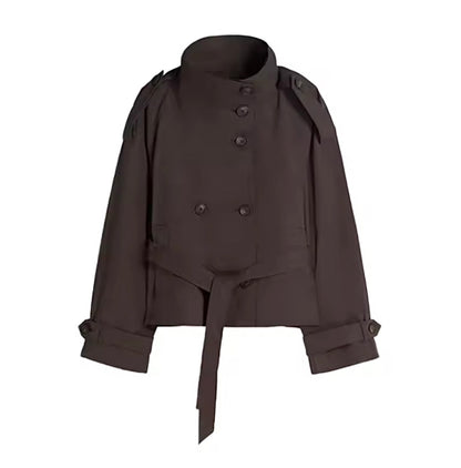 A dark brown cropped trench jacket with a high stand collar, double-breasted front, shoulder epaulets, and a self-tie belt at the waist, shown against a plain white background.